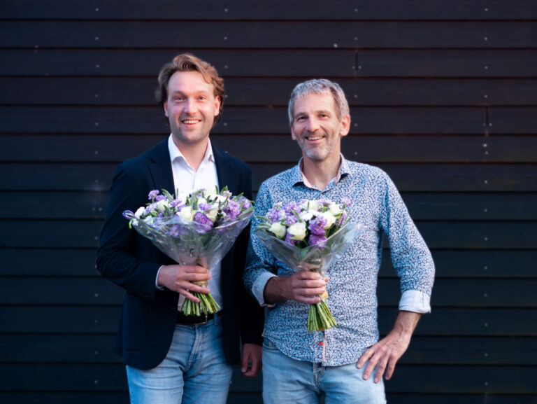 Melvin Smit (links) en André Bus (rechts) met een bos bloemen